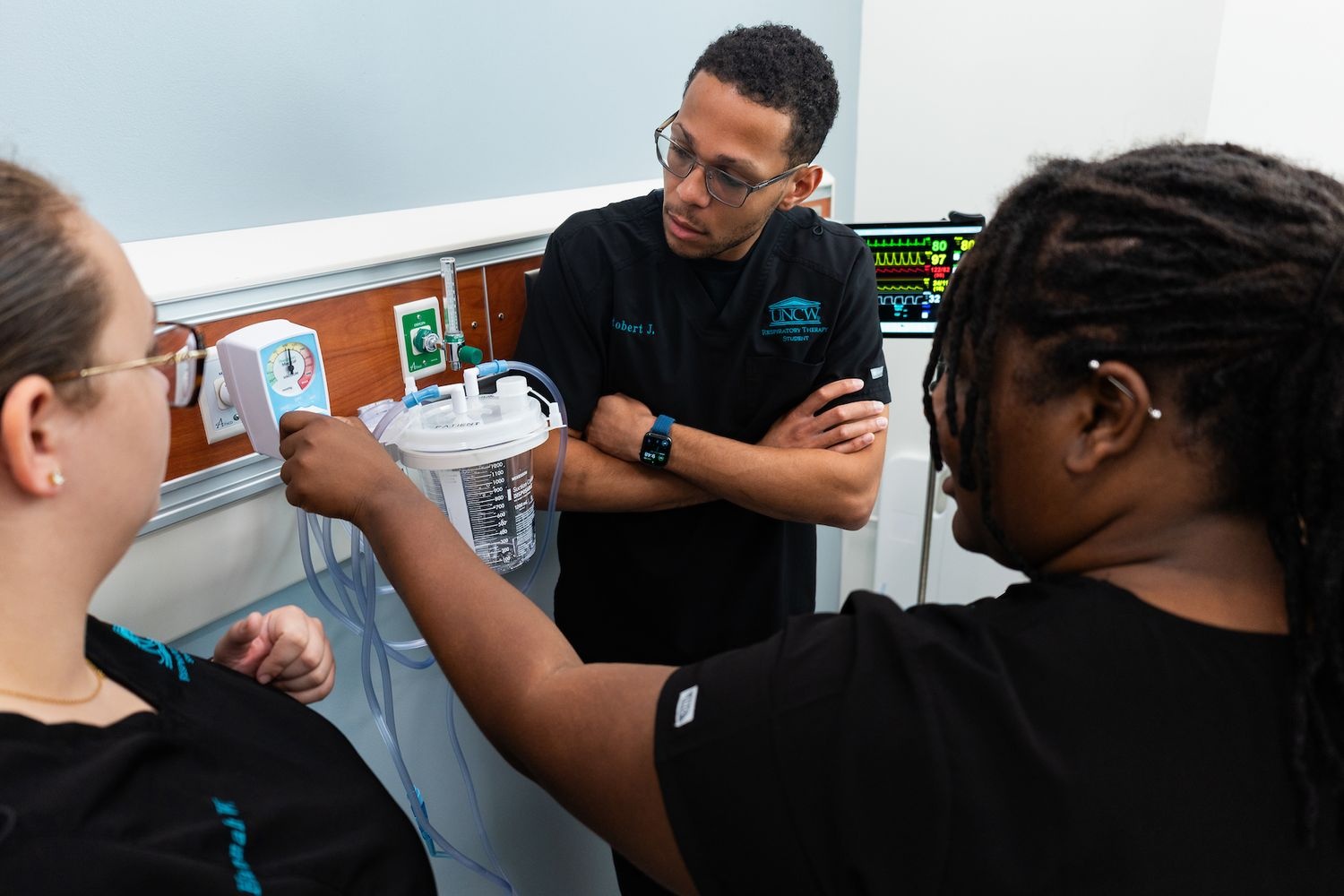 A respiratory therapy student adjusts the Precision Medical Vacuum during a hands-on clinical experience 