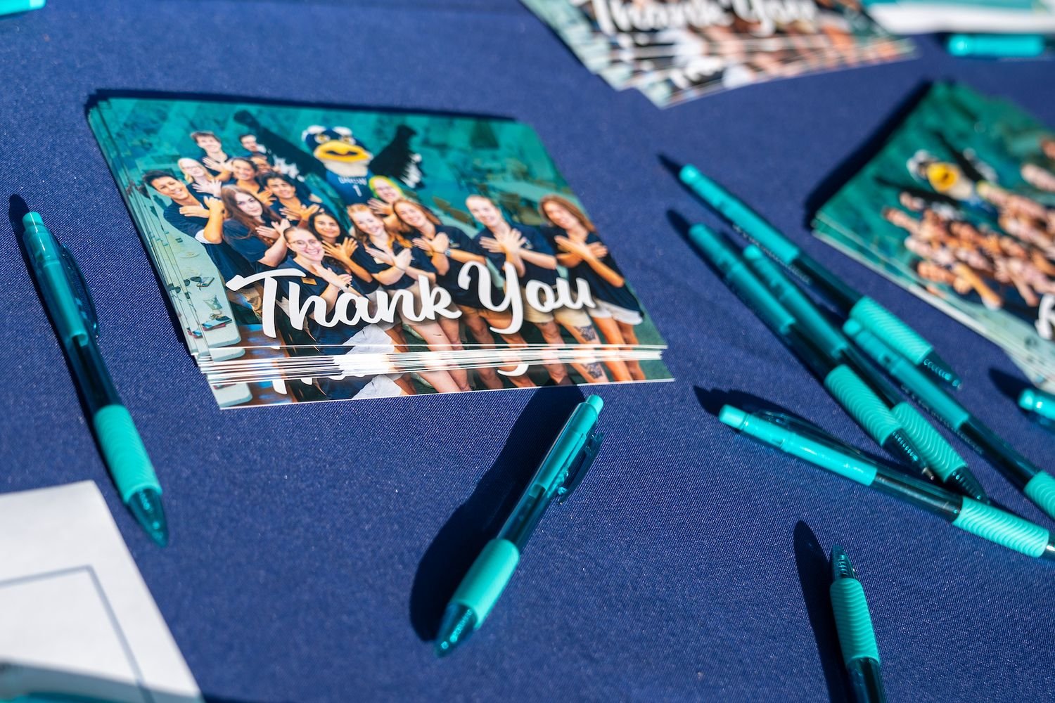 Thank you cards with UNCW items scattered on a table