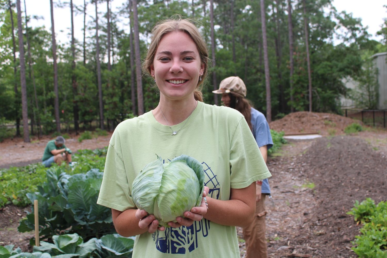Student holding lettuce that was harvested in the garden