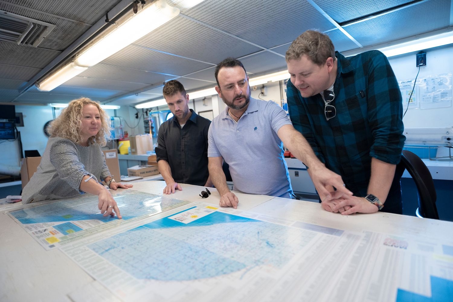 Teal Ships crew working together with maps