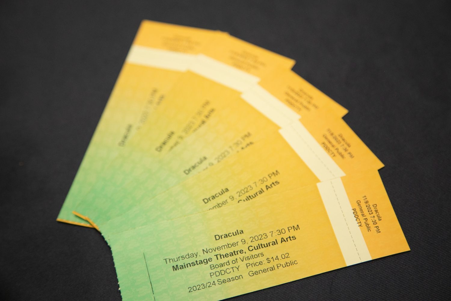 5 tickets to a Dracula theme play laying on a table