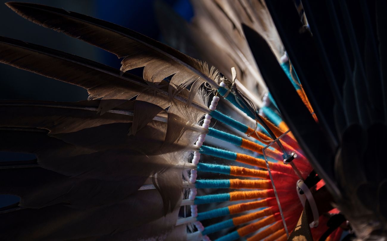 An Indigenous headdress with light shining through the feathers