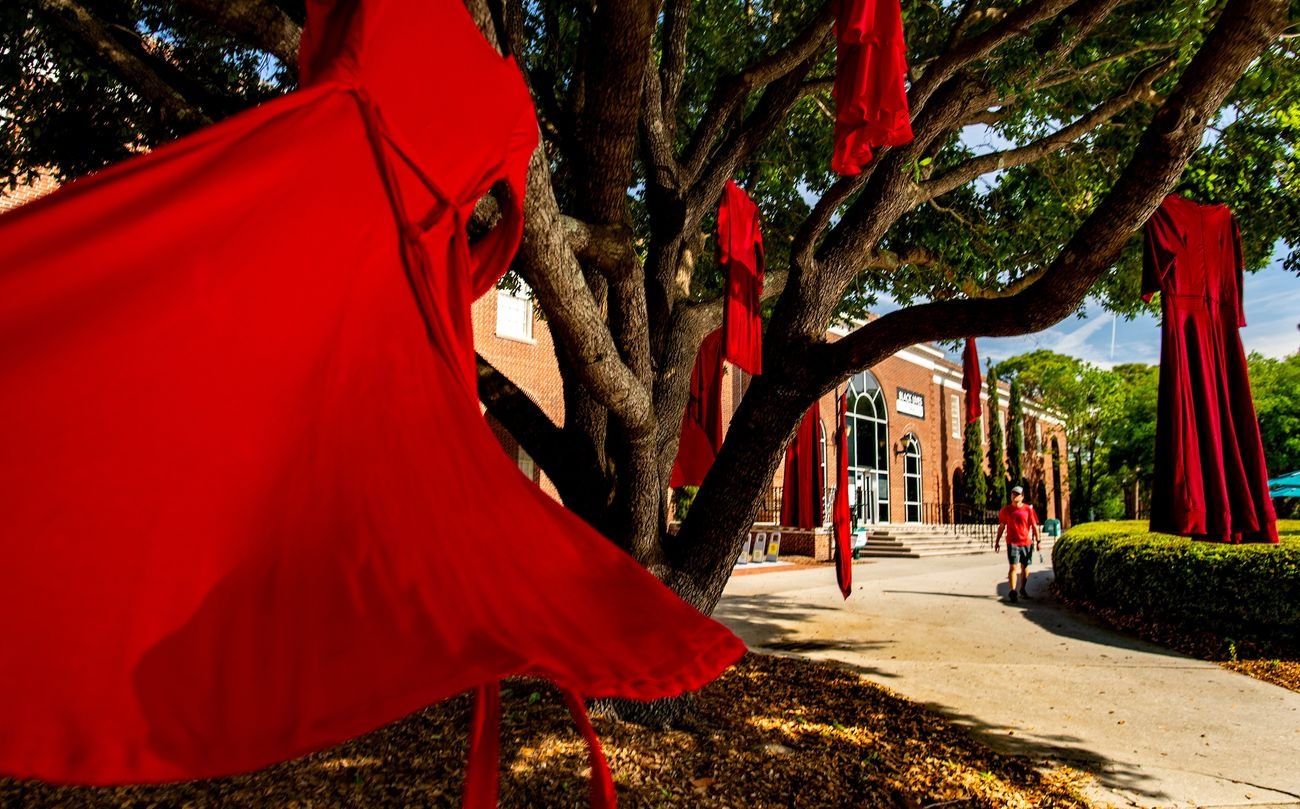 Red dresses hanging from tree