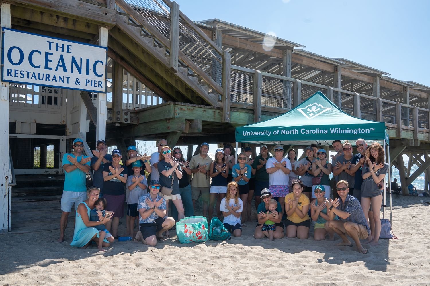 Participants in Weekend in Wilmington pose for a photo at Crystal Pier in Wrightsville Beach.