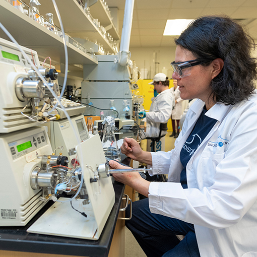 A professor using a machine in the Drug Discovery Lab