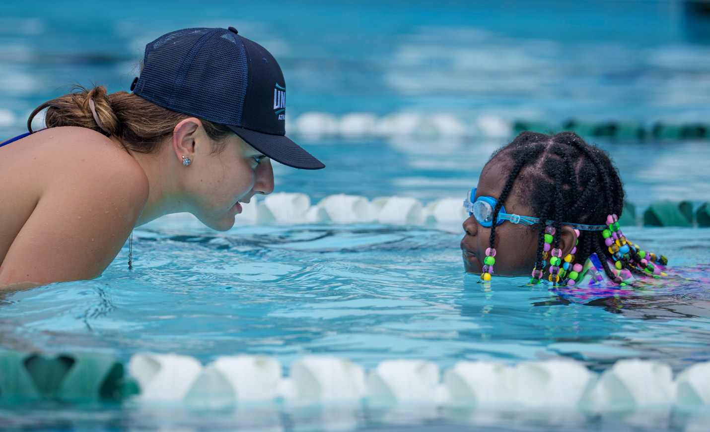Instructor cheers on youth as they swim