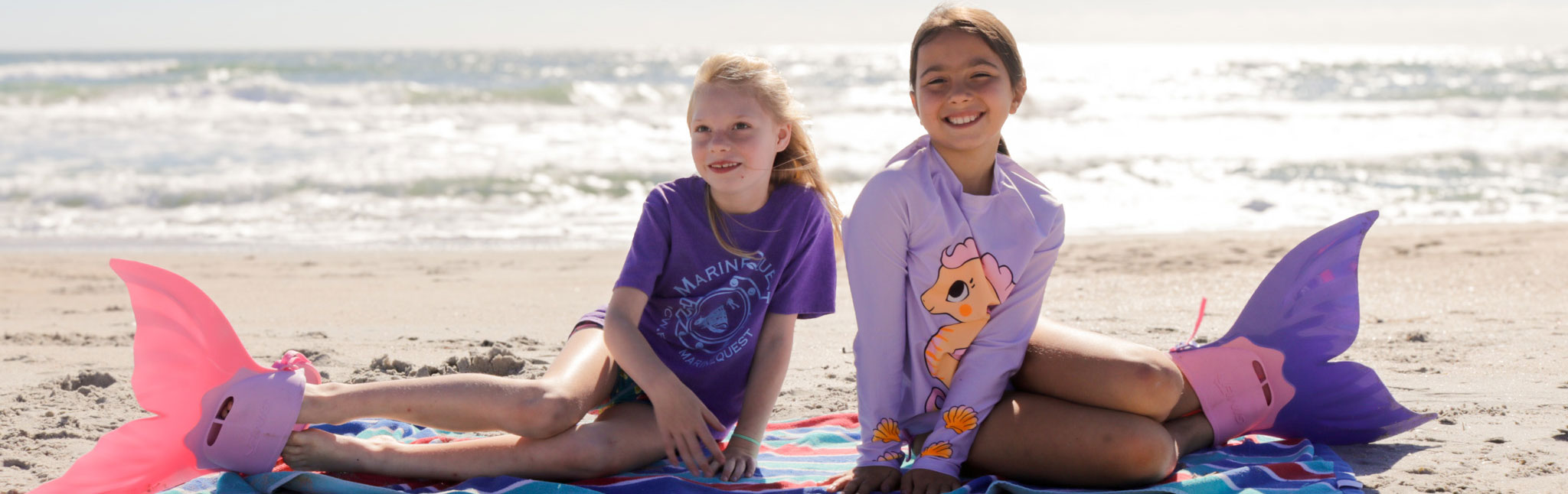 Camp youth on the beach wearing mermaid flippers
