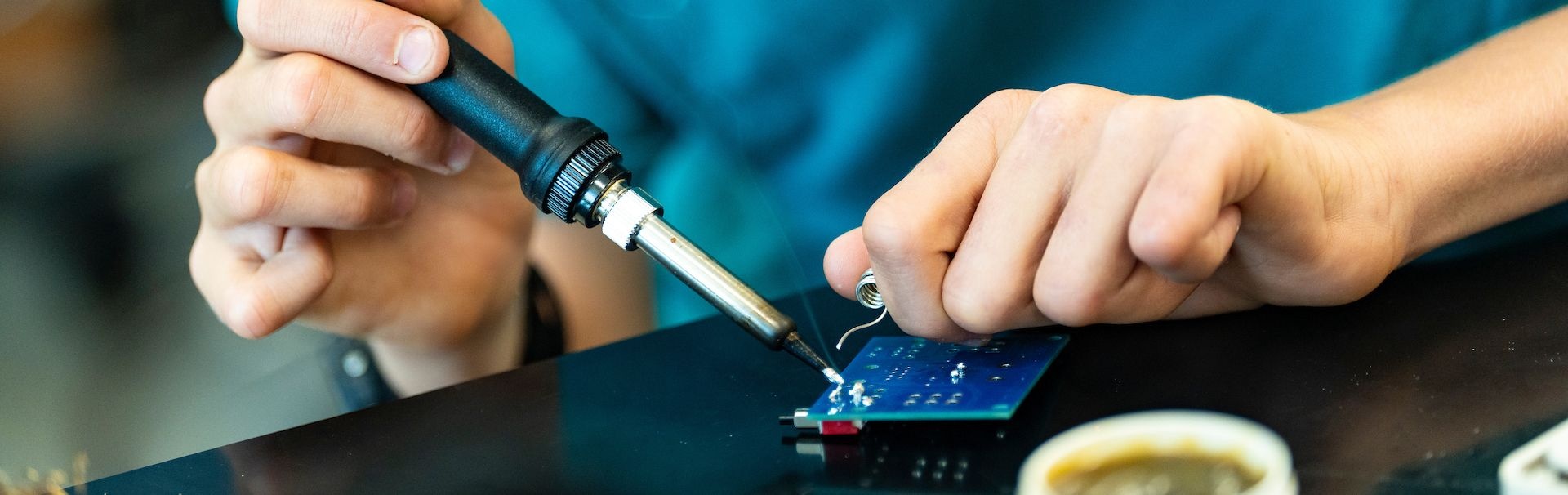 Camper learning how to solder a circuit board