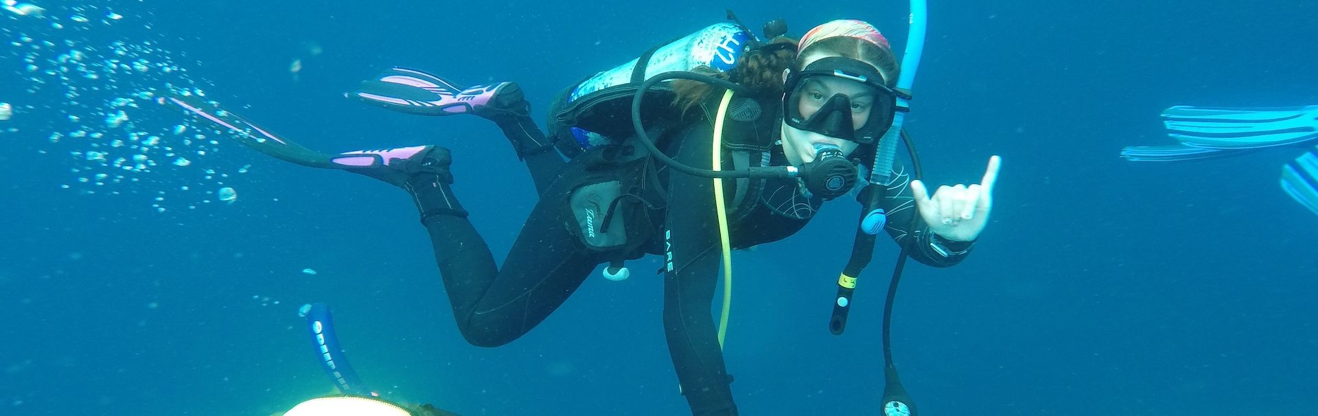 Scuba diver throwing the "hang loose" hand gesture in the water