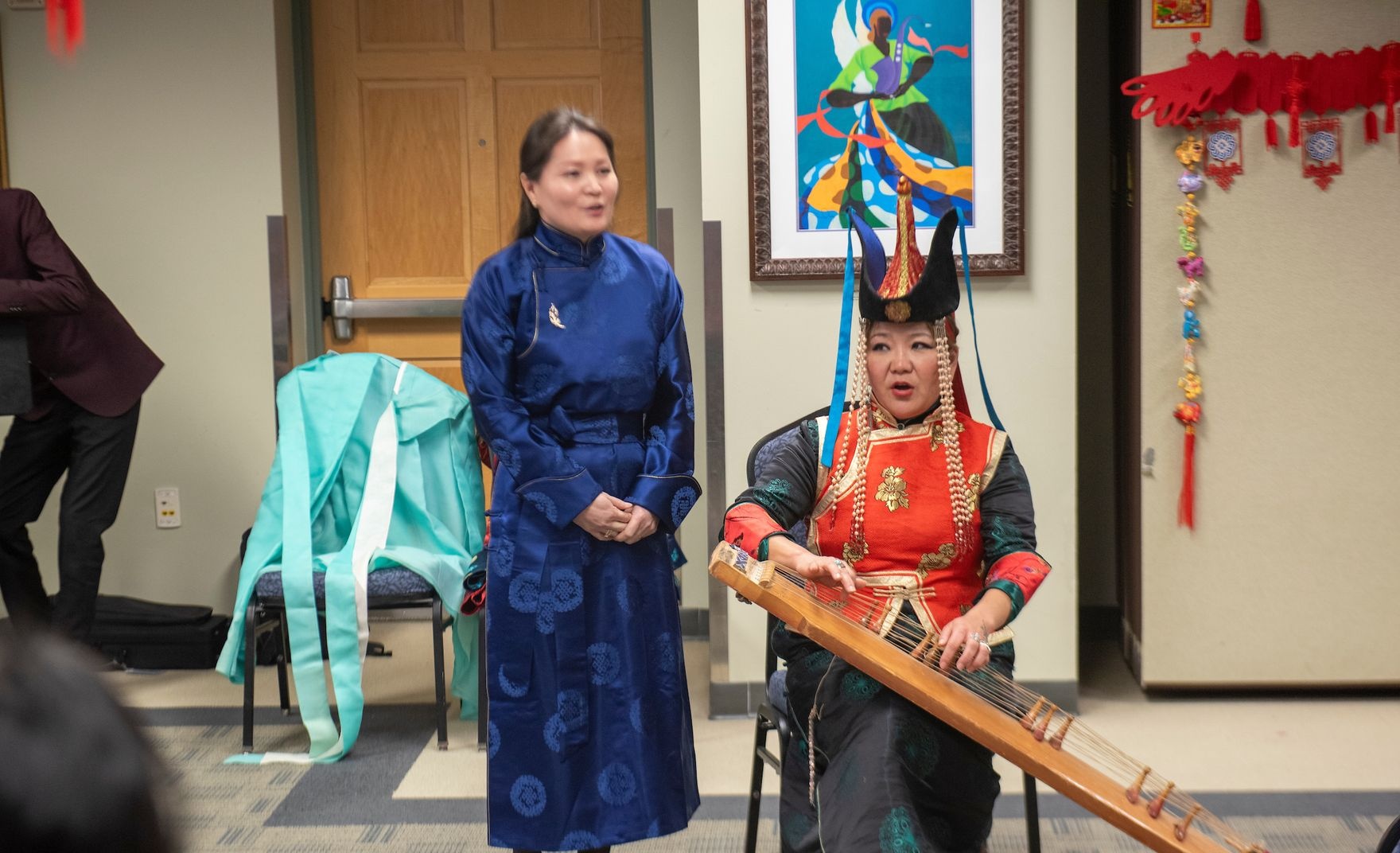 AHCC member sits as they play a stringed instrument