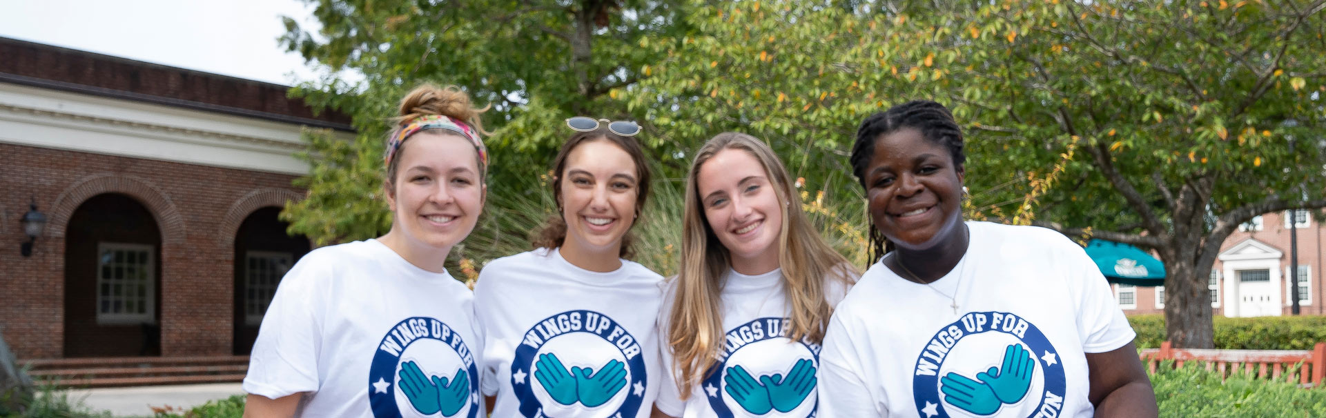 Four students with Wings up for Wilmington shirts