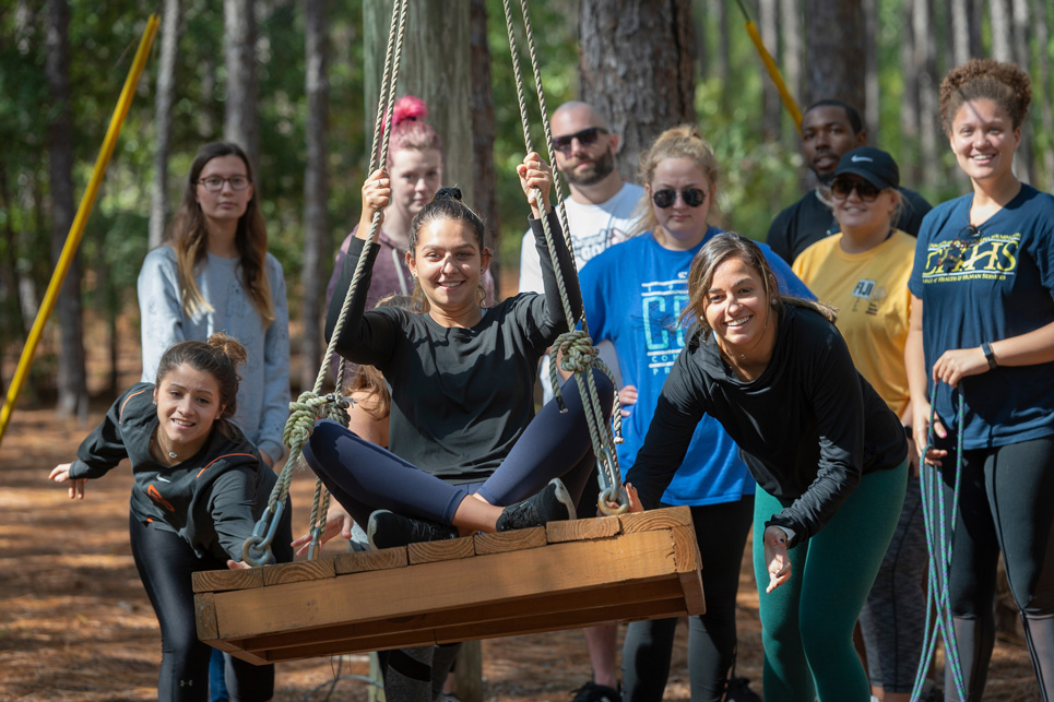 Students engage in a low ropes platform swing activity on the Challenge Course