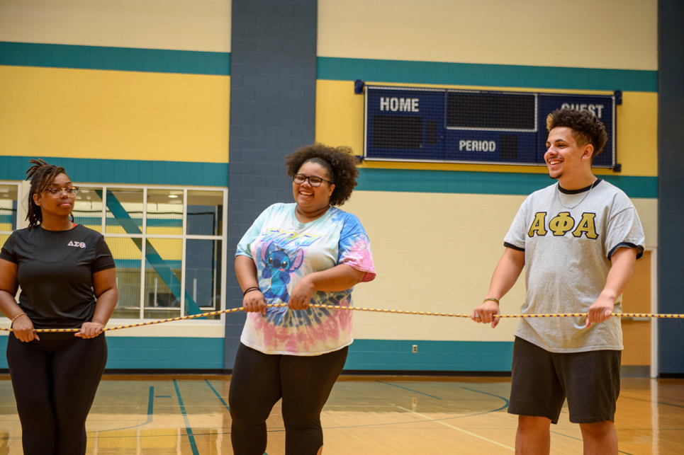 Students seen laughing inside a gym while engaging in a team building activity