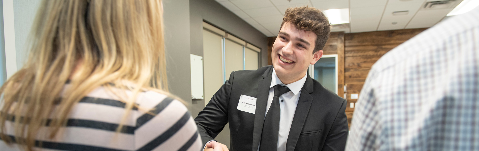  A student shakes hands with prospective employers at a job fair