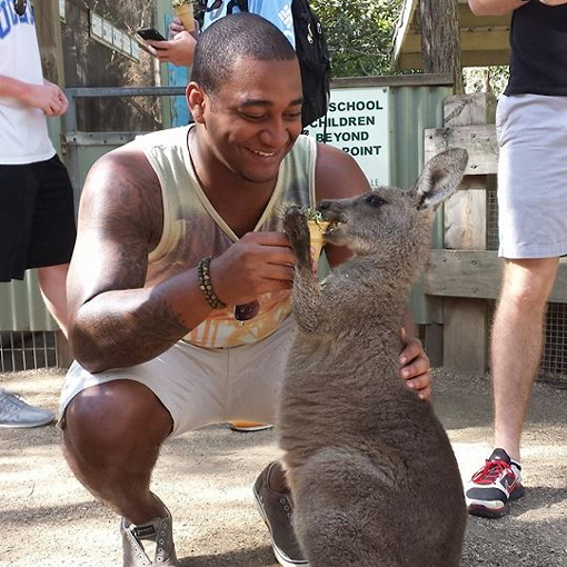 UNCW student feeding a kangaroo in Australia