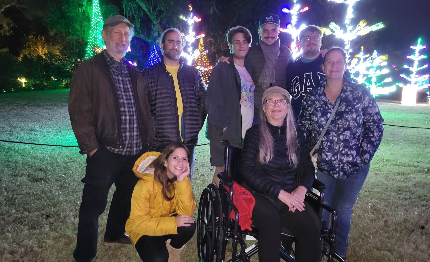 group of 8 iss people in front of Christmas lights